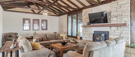 Large living room for gathering, smart tv and oversized windows looking into the backyard pool area