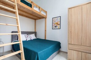 A cozy sleeping area with a bunk bed and a wardrobe, perfect for maximizing space.

