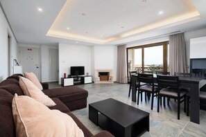 A lovely living area with a comfortable sofa, cable TV, a dining area, and balcony access #cozy #home #comfort #decoration
