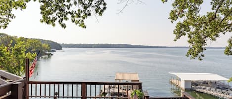 Lake views and waterfront property that includes a private boat dock and lawn.