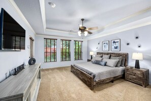 Master Bedroom. The room has a king-size bed, a smart TV, and bedside lamp-table cabinets.