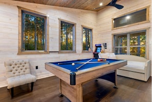 Vibrant game room with pool table, arcade games, & twin beds