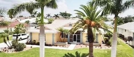 Incredible home is surrounded by large palms and tropical landscaping.  