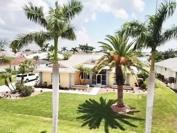 Incredible home is surrounded by large palms and tropical landscaping.  