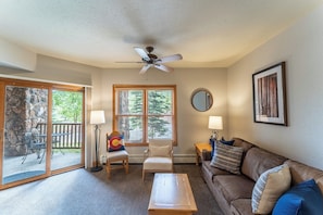 Living area offering cozy furnishings, a gas fireplace and ceiling fan.