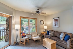 Living area offering cozy furnishings, a gas fireplace and ceiling fan.