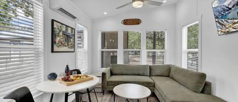 The snug living room seamlessly transitions into a quaint dining area, creating an intimate and charming space