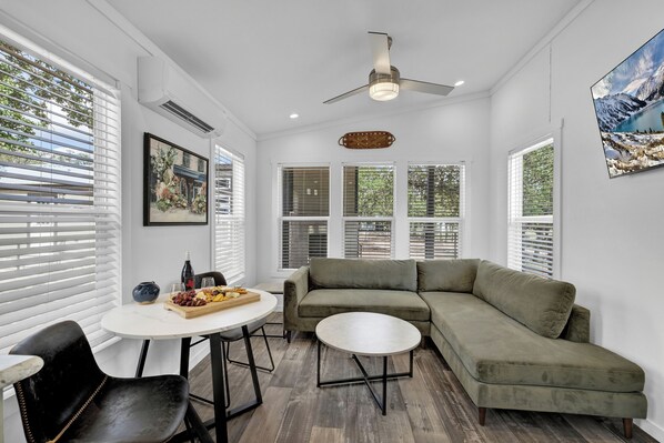 The snug living room seamlessly transitions into a quaint dining area, creating an intimate and charming space