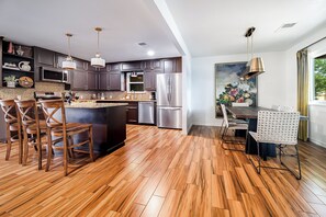 This home boasts an open layout that effortlessly connects the living room, dining area, and kitchen into one cohesive, welcoming space.