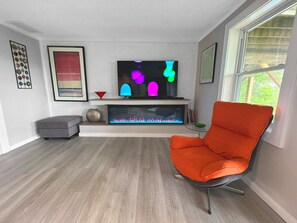 Large smart TV and electric fireplace in ground floor den