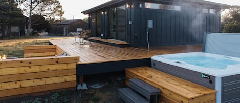 The hot tub and fire pit are both on the ocean side of the house at Moran Shores