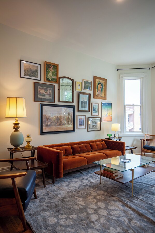 Living room includes an original bay window with stained glass and ample seating