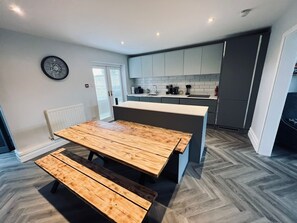 Patio doors leading onto terrace, kitchen with bench seating, induction hob