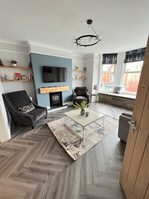 Cosy lounge with big bay window, Roman blinds, window seat and electric fire
