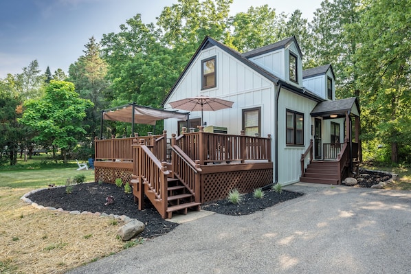 Front view of the house.  Large deck, landscaped yard, and plenty of parking.