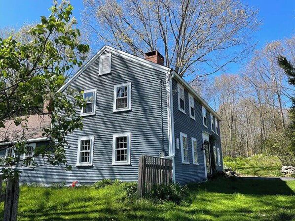 A field to one side, large lawn and woods trails out back, overgown gardens too.