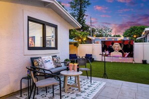 Enjoy outdoor movies under the string lights with our private backyard setup.