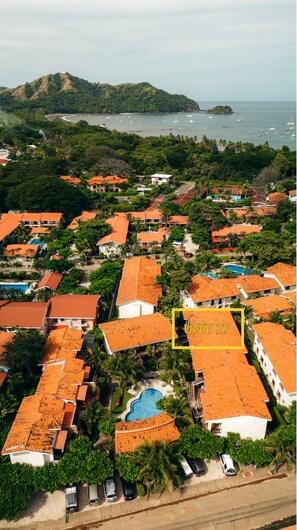 Unit 27 visible from above, along with the parking, and three of the four pools available at the complex