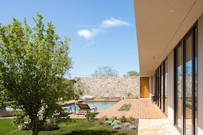 View of the large swimming pool with deckchairs for rest and relaxation in the famous luxury air-conditioned villa Serenity Pula in Istria for rent  surrounded by greenery