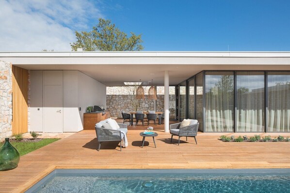 A spacious terrace with a sunbathing area for relaxing next to the large swimming pool of a private family villa  Serenity Pula 3 for rent in Istria 