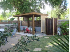 Vue d'ensemble du jardin clôturé avec salon, kiosque et douche extérieure