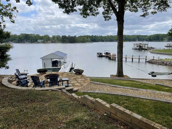 view of lake, firepit, dock & hammock