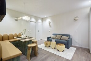 Salon avec espace repas, cuisine et canapé lit