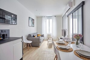 Séjour avec canapé lit double, télévision et cuisine américaine 