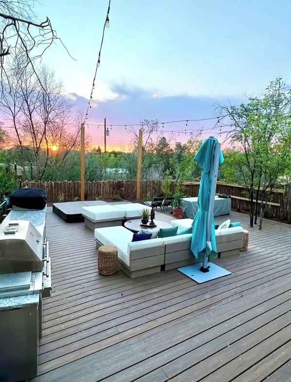 Sprawling, private back deck, including grill, sofa, table and hot tub.