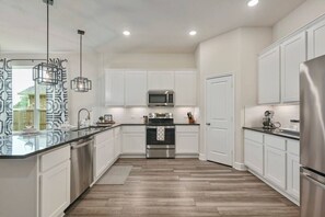 Large open kitchen space with stainless steel appliances.