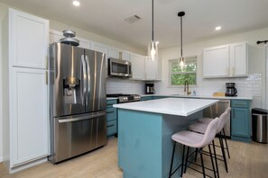 Kitchen - open-concept and fully stocked with island & seating.