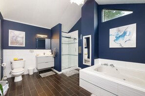 Soak, steam, and refresh in style! This spacious bathroom features a jetted tub, glass shower, sleek vanity, and calming navy tones—perfect for a little self-care luxury. ✨🧖