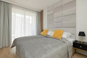 Bright and cozy bedroom with a comfortable double bed, soft gray bedding, and vibrant yellow accents.

