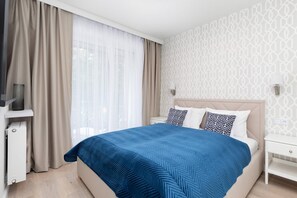 Cozy bedroom featuring a comfortable double bed with blue accents and soft lighting.