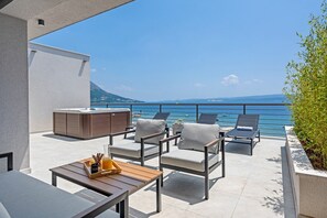 Die oberste Etage bietet eine Terrasse mit Whirlpool, Liegestühlen und einer überdachten Lounge-Ecke