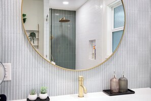 Primary bath with large rain shower and spacious vanity area.