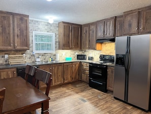 Fully equipped kitchen with dishwasher, stove, fridge, and microwave