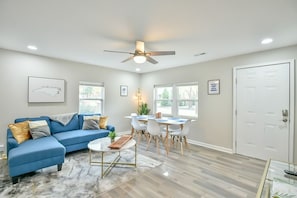 Living room with 65" Roku smart TV, chaise couch, and dining table
