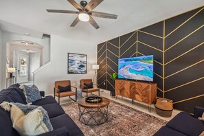 Living room w/sleeper sofa. Open concept, high ceilings, lots of room to gather