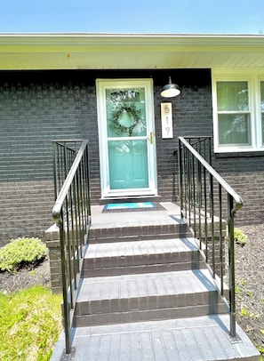 Front Entryway off driveway with a few steps, and a. digital. lock..