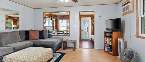 The living room features a sectional sofa, tv, ceiling fan, and air conditioner.