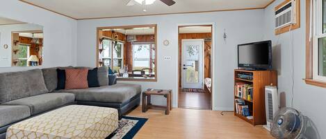 The living room features a sectional sofa, tv, ceiling fan, and air conditioner. 