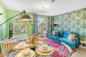 As you step into the dining room, your eyes are immediately drawn to the vibrant centerpiece - a truly captivating and colorful dining table that exudes an air of lively elegance. 
