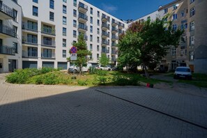 Courtyard view with greenery and modern apartment buildings, creating a welcoming atmosphere.

