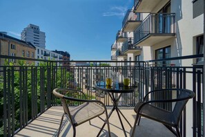 Balcony with outdoor seating and a lovely view of the modern neighborhood.

