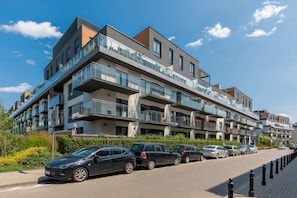 Exterior view of the apartment complex with modern architecture and convenient parking.


