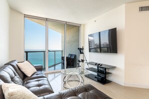 Relax in a living room with a comfortable sofa, a large TV, and breathtaking ocean views.