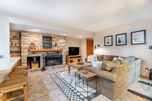 Living area offering cozy furnishings, a stacked stone fireplace, Roku streaming, and a record player.