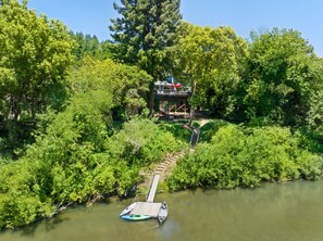 Moondance on the Russian River with seasonal boats and dock.