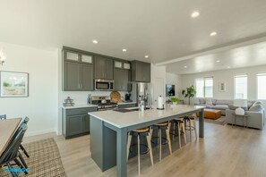 Contemporary culinary oasis: Open kitchen equipped with modern amenities, sleek appliances, and four chic bar stools. Embrace the perfect blend of functionality and style in this inviting space, where cooking becomes a delightful experience.